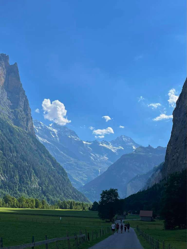 hiking path through lauterbrunnen valley with mountains towering on the side