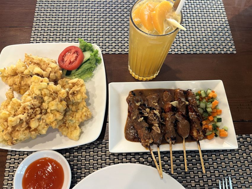 Corn fritters, chicken satay, and lemongrass ginger tea at Batavia Café in Hanoi