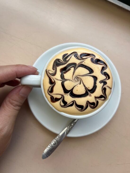 Hot egg coffee with decorative artwork on the creamy topping in Hanoi