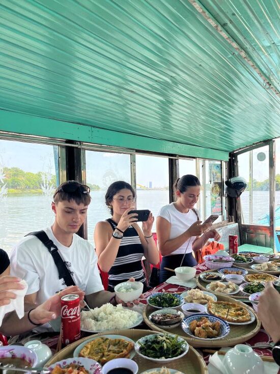 Family-style lunch aboard a dragon boat on the Perfume River in Hue